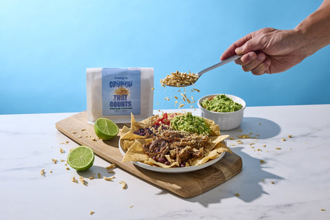 Lightly Salted Protein Topping over loaded nachos with guacamole and lime