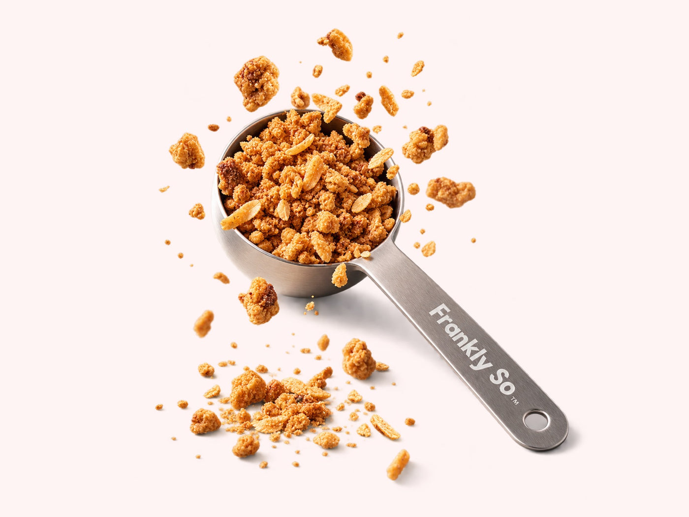 The Frankly So Super Scooper heaped with protein crumble, crumbs scattered around it